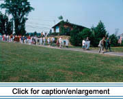 Carrying family banners, parishioners walk from St. David Catholic Church in Madawaska to the Acadian Landing Site following a special Acadian Festival mass.