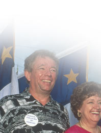 Educator Ross Paradis and his wife, Maine State Senator Judy Paradis, with Acadian flags at the Acadian Festival Parade in Madawaska, 1995. Photographer: Paula Lerner,   2003.
